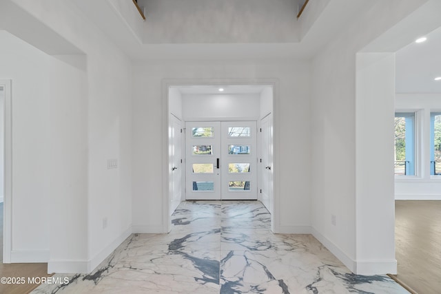 entryway featuring a tray ceiling and french doors