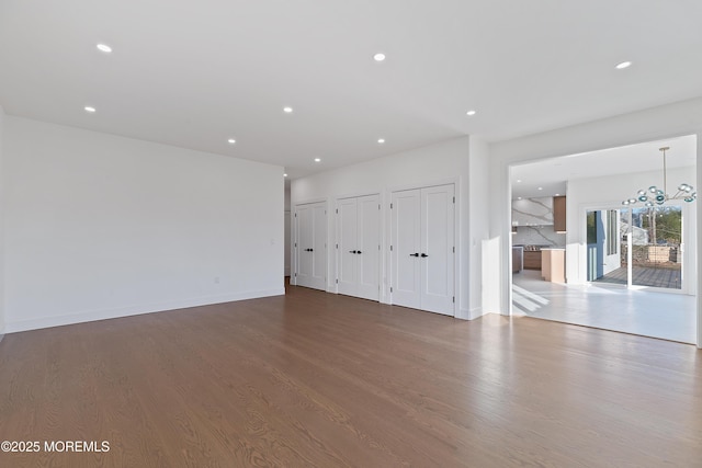 unfurnished living room with a notable chandelier and hardwood / wood-style flooring