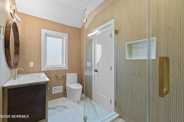 bathroom featuring vanity, toilet, a shower with shower door, and lofted ceiling