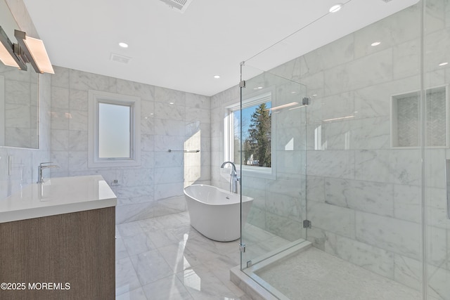 bathroom featuring vanity, separate shower and tub, and tile walls