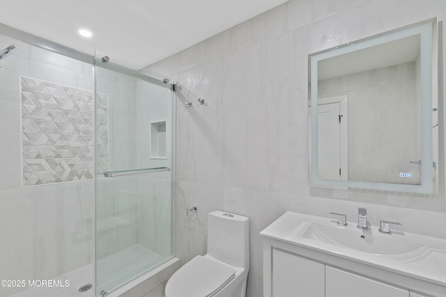 bathroom featuring an enclosed shower, vanity, toilet, and tile walls