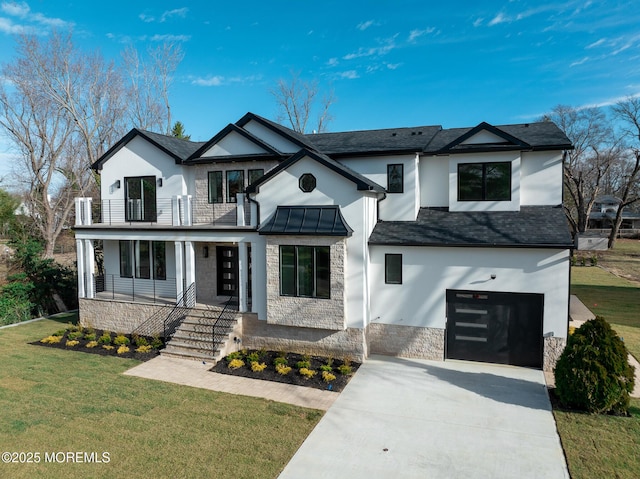 view of front of property featuring a garage, a balcony, and a front yard