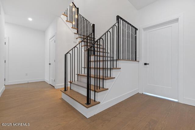 staircase with hardwood / wood-style floors