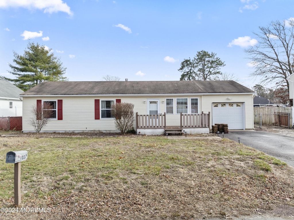 single story home featuring a garage, a front lawn, and a wooden deck