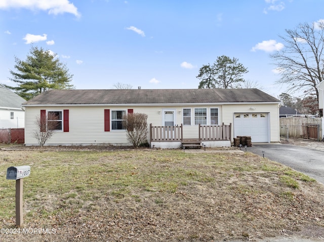 single story home featuring a garage, a front lawn, and a wooden deck