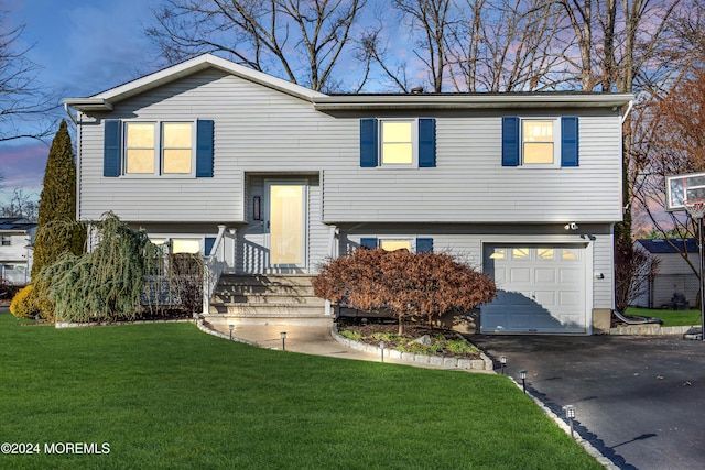 split foyer home with a yard and a garage