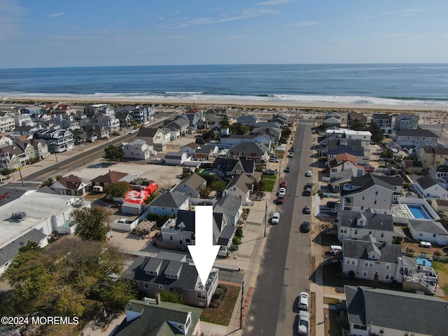 drone / aerial view featuring a water view and a beach view