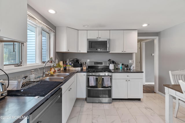 kitchen with white cabinets, appliances with stainless steel finishes, and sink