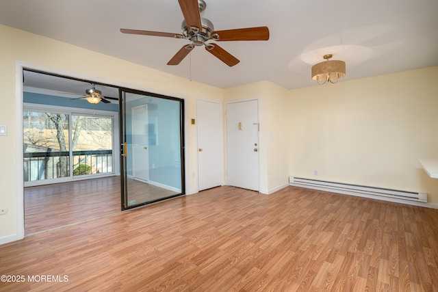 spare room with light wood-type flooring and a baseboard heating unit