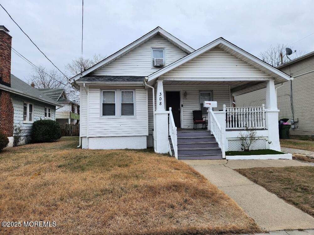 bungalow-style home featuring a porch and a front lawn