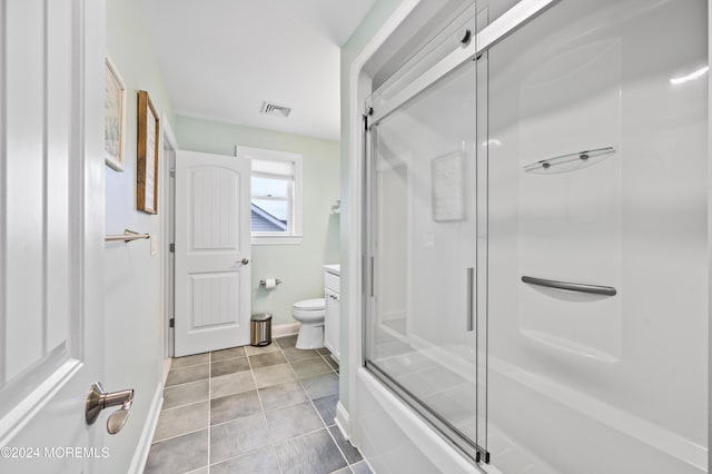 full bathroom with tile patterned floors, vanity, toilet, and bath / shower combo with glass door