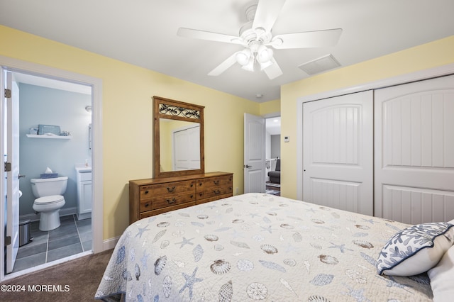 carpeted bedroom with ensuite bath, a closet, and ceiling fan