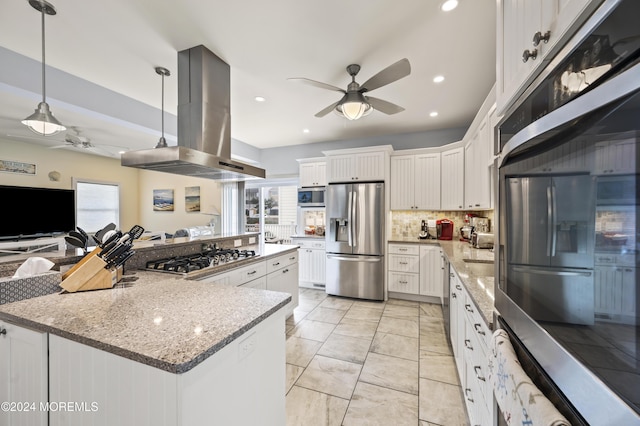 kitchen with stainless steel appliances, island range hood, a spacious island, white cabinetry, and hanging light fixtures