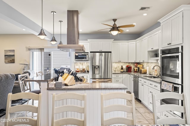 kitchen featuring sink, stainless steel appliances, island exhaust hood, decorative light fixtures, and white cabinets