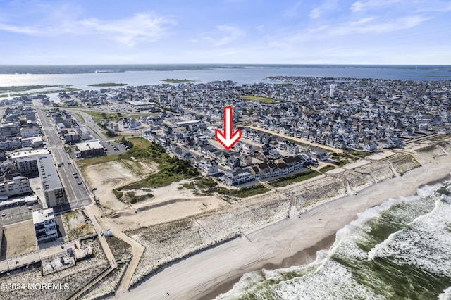 birds eye view of property featuring a water view and a beach view