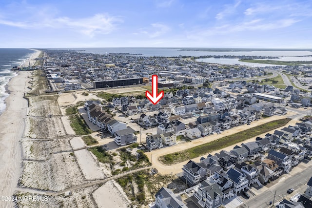 drone / aerial view featuring a water view and a view of the beach