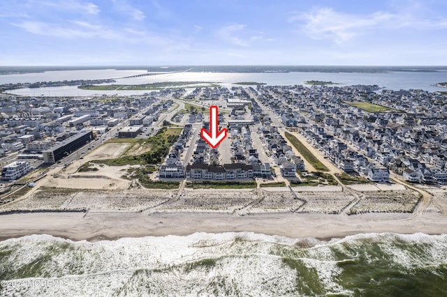 drone / aerial view featuring a beach view and a water view