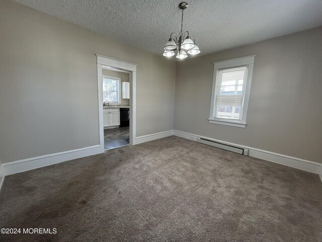 carpeted spare room with a chandelier, a textured ceiling, and a baseboard radiator