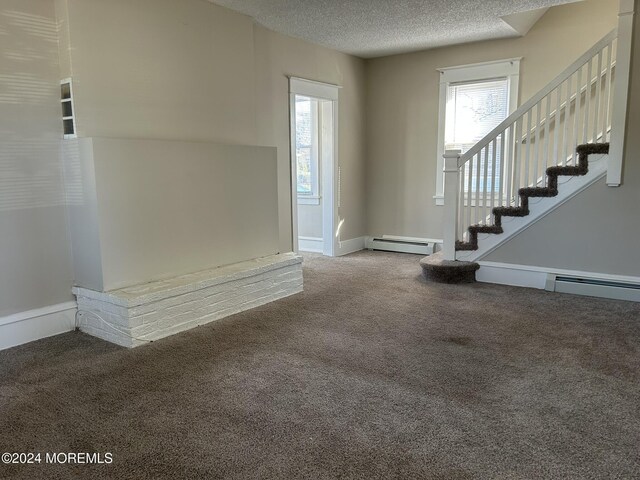 entrance foyer with carpet, a textured ceiling, and a baseboard heating unit