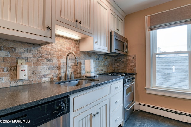 kitchen with a baseboard heating unit, sink, decorative backsplash, appliances with stainless steel finishes, and white cabinetry