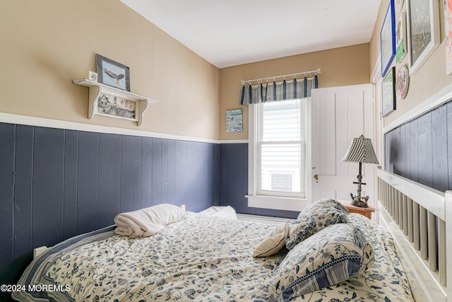 bedroom featuring wood walls