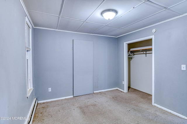 unfurnished bedroom featuring light carpet, baseboard heating, and a closet