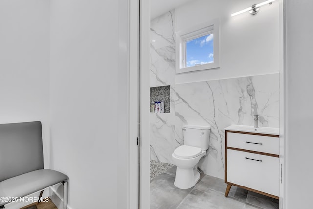 bathroom with concrete flooring, vanity, and toilet