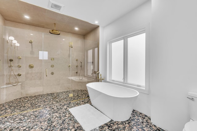 bathroom featuring toilet and independent shower and bath