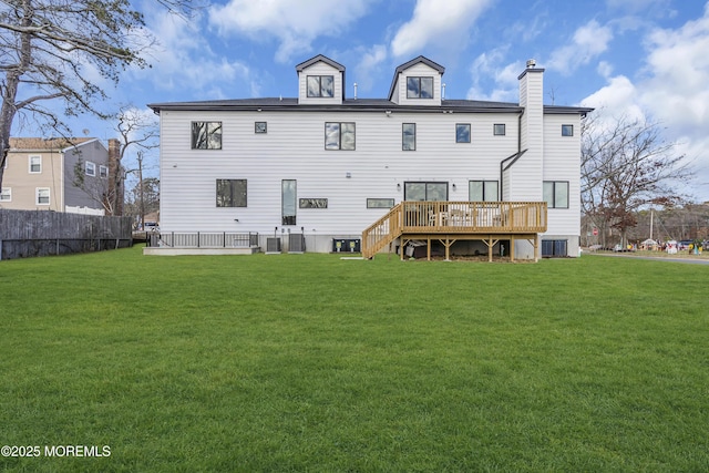 rear view of property featuring a lawn, cooling unit, and a wooden deck