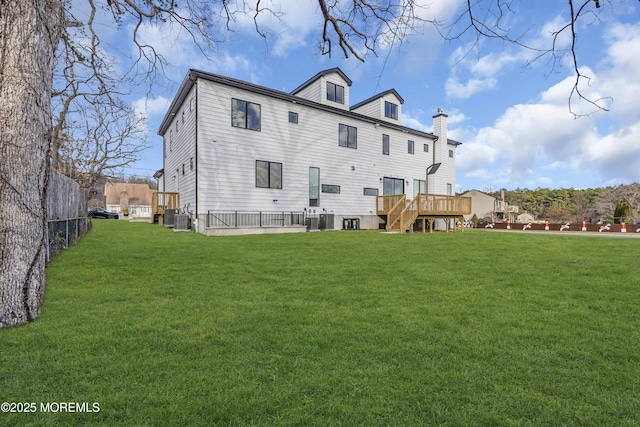 rear view of house featuring a yard, central AC unit, and a wooden deck