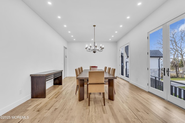 dining room featuring french doors, light hardwood / wood-style flooring, and a notable chandelier