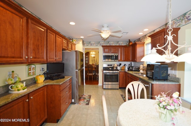 kitchen with ceiling fan, sink, stainless steel appliances, pendant lighting, and light tile patterned flooring