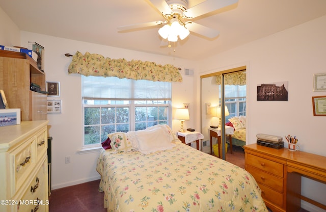 bedroom featuring ceiling fan, dark carpet, and a closet