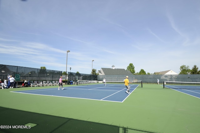 view of tennis court featuring basketball hoop