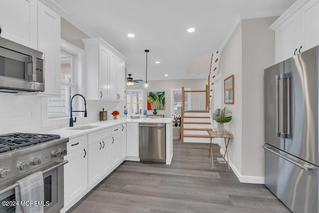 kitchen featuring hanging light fixtures, backsplash, white cabinetry, and high end appliances