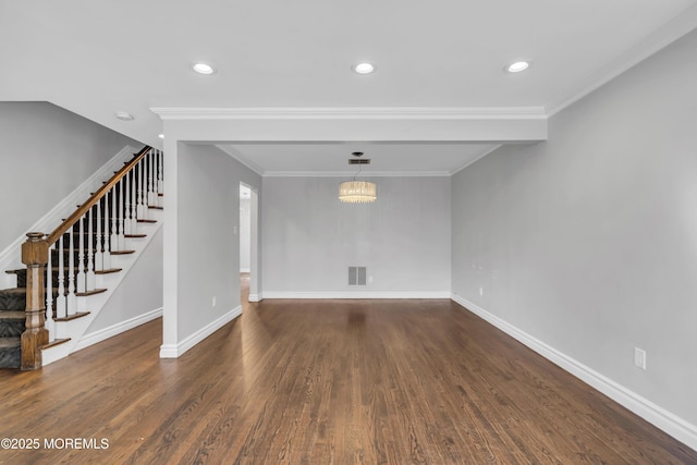 unfurnished living room featuring ornamental molding, dark wood-type flooring, and an inviting chandelier