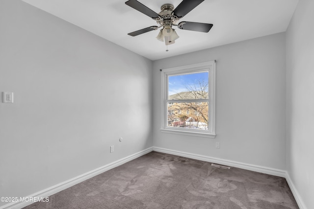 carpeted spare room featuring ceiling fan