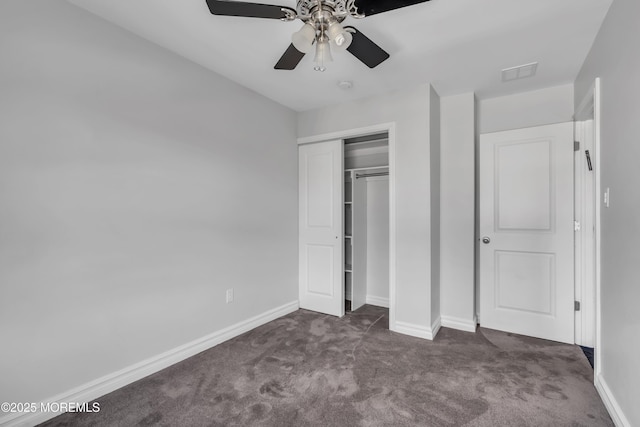 unfurnished bedroom with a closet, dark carpet, and ceiling fan