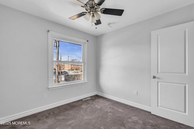 unfurnished room with dark carpet and ceiling fan