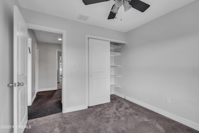 unfurnished bedroom with ceiling fan, a closet, and dark colored carpet