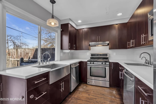 kitchen with pendant lighting, sink, appliances with stainless steel finishes, and dark wood-type flooring