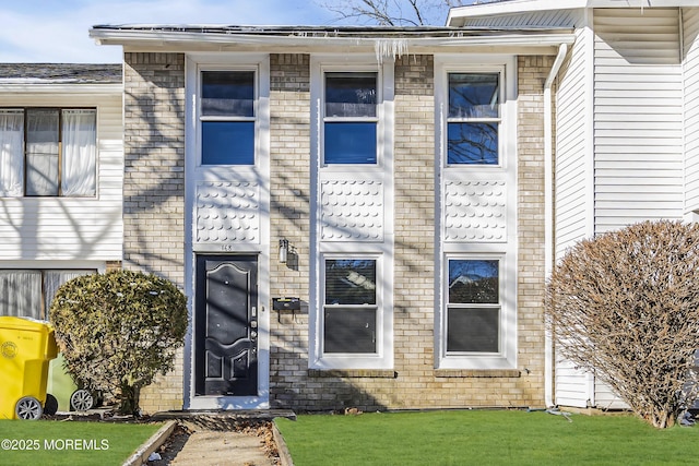 view of exterior entry featuring a yard