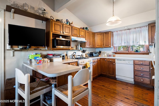 kitchen featuring hanging light fixtures, vaulted ceiling with beams, kitchen peninsula, white appliances, and a breakfast bar area