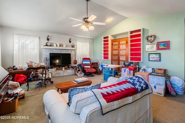 living room with ceiling fan, carpet floors, and vaulted ceiling