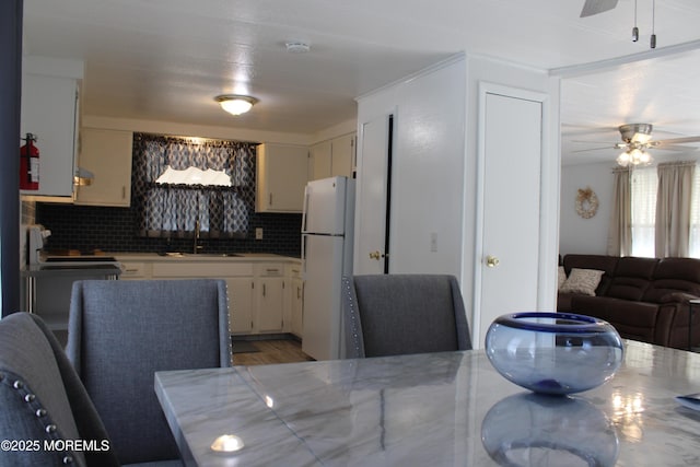 dining room with ceiling fan and sink