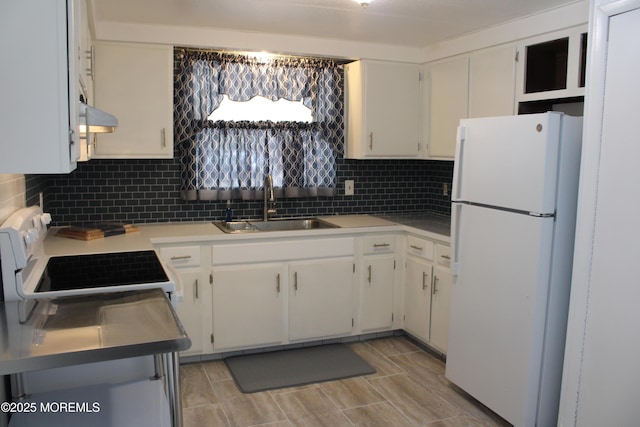 kitchen with stove, white cabinets, sink, tasteful backsplash, and white fridge