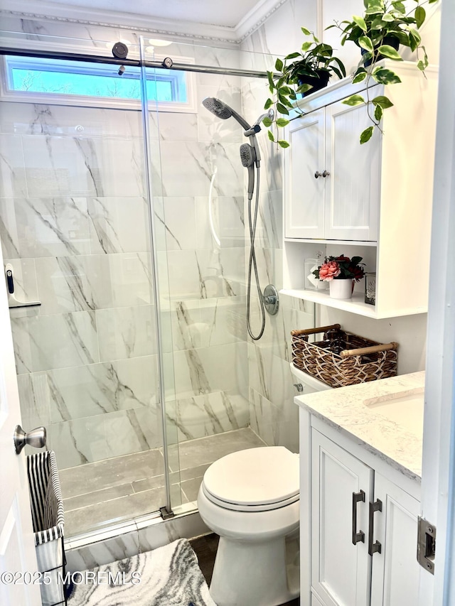 bathroom with toilet, an enclosed shower, and vanity