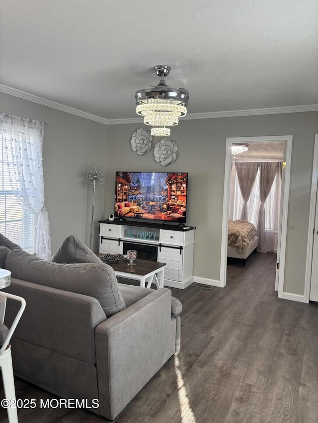 living room with an inviting chandelier, crown molding, and dark hardwood / wood-style flooring