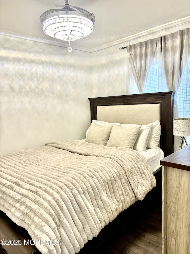 bedroom with ornamental molding and hardwood / wood-style flooring