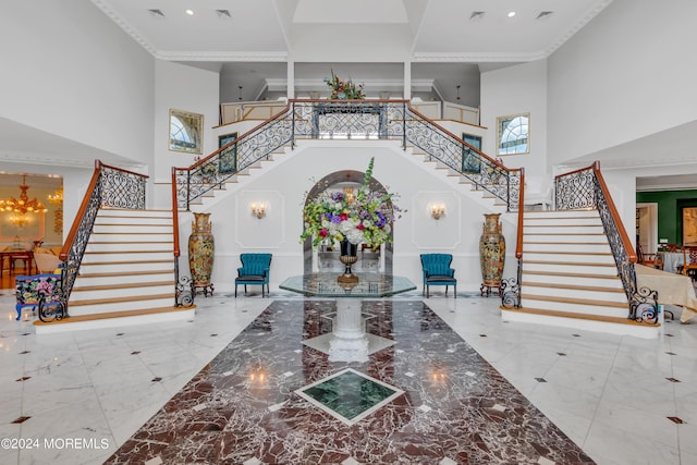 foyer with crown molding and a towering ceiling